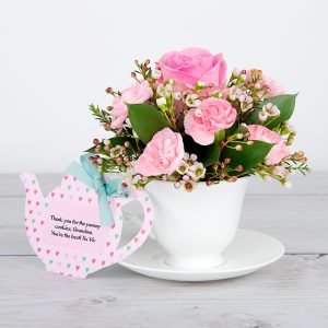 Pink Roses, Spray Carnations, White Waxflower and Dried Poppy Heads inside Bone China Teacup and Saucer